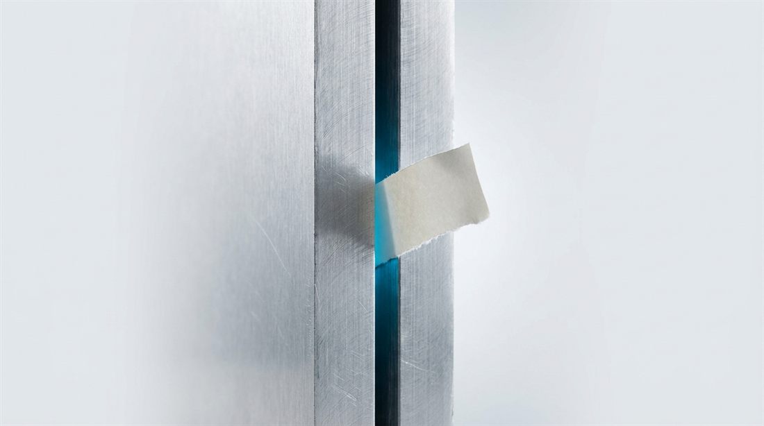 Two aluminum plates almost touching, a paper slip caught in the glowing gap between them